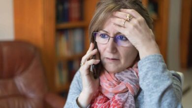 white woman talking on the phone and receiving bad news with a worried face.